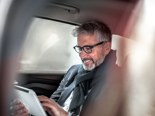 Picture of a man with a tablet in a car