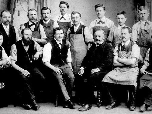 A group of men pose for a black and white photo from 1888