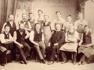 A group of men pose for a black and white photo from 1888
