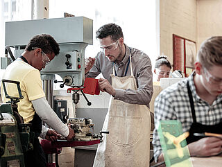 A group of people working on a machine in a workshop