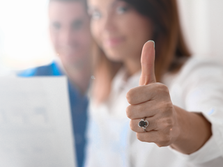 A woman makes a "thumbs-up gesture"